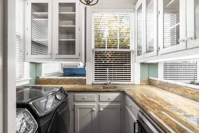 kitchen with sink, separate washer and dryer, and gray cabinetry