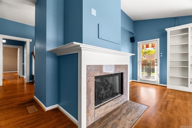 unfurnished living room with dark wood-type flooring and a fireplace