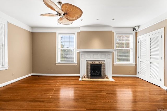 unfurnished living room with hardwood / wood-style floors, a fireplace, and a wealth of natural light