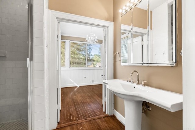 bathroom featuring hardwood / wood-style flooring, walk in shower, and a chandelier