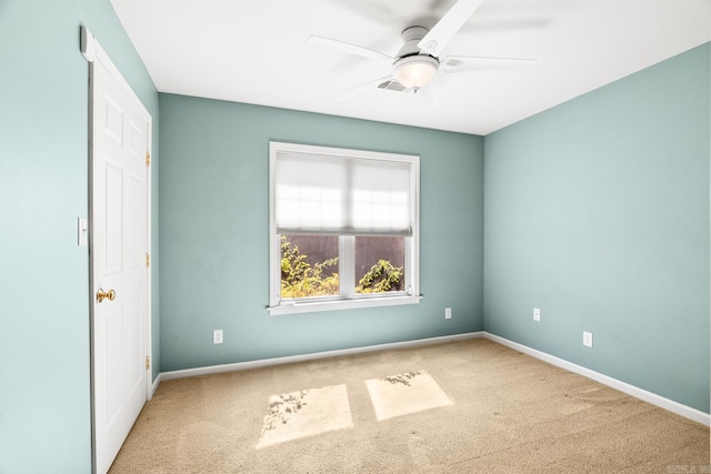 carpeted spare room with ceiling fan