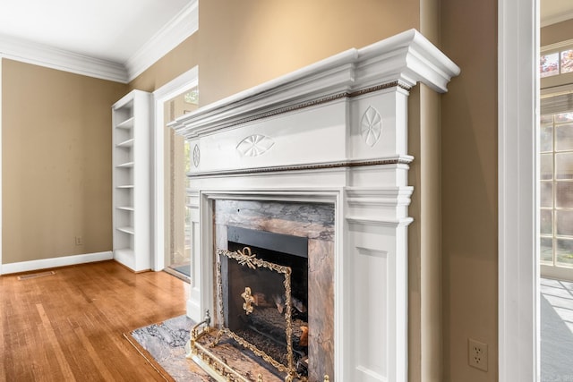 details with ornamental molding, a high end fireplace, and wood-type flooring