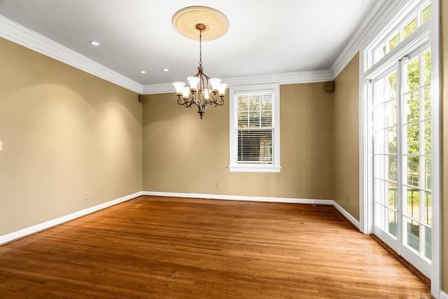 unfurnished room with light hardwood / wood-style floors, a chandelier, and plenty of natural light