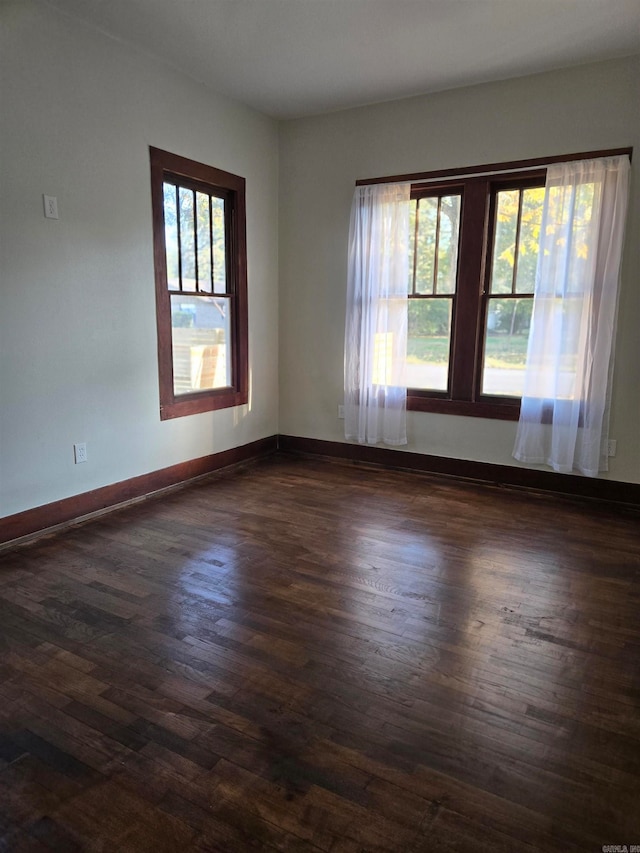 unfurnished room with dark wood-type flooring