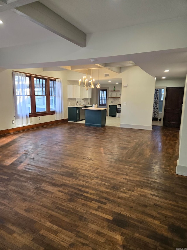 unfurnished living room with beam ceiling, sink, dark wood-type flooring, and a notable chandelier