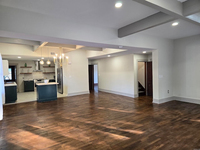 unfurnished living room with beamed ceiling, dark hardwood / wood-style floors, sink, and a notable chandelier