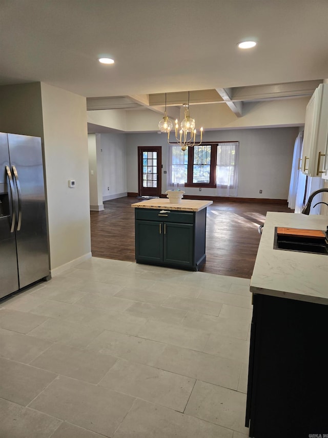 kitchen with pendant lighting, a center island, sink, stainless steel fridge, and light hardwood / wood-style floors