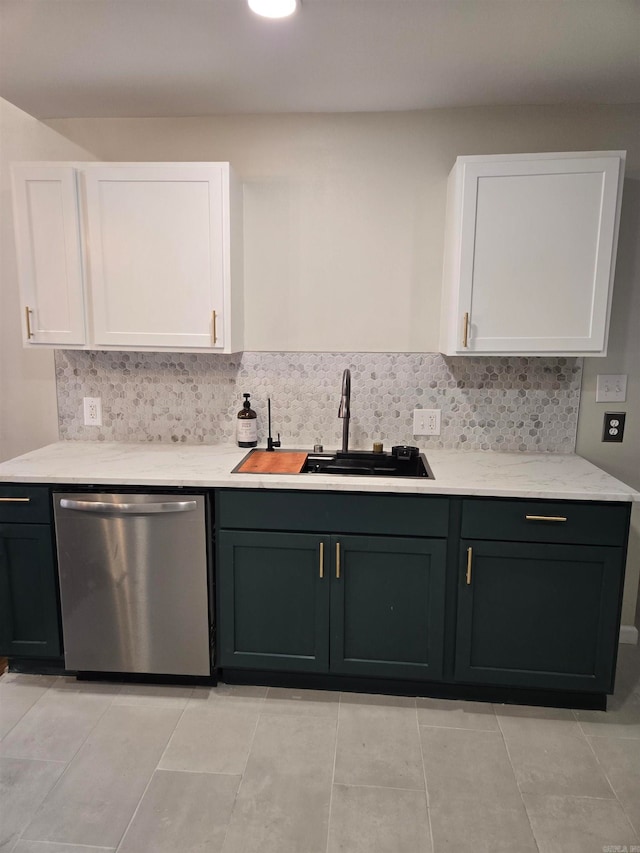 kitchen with backsplash, white cabinetry, sink, and stainless steel dishwasher