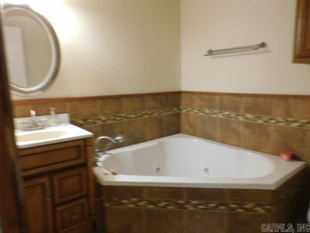 bathroom with vanity and a relaxing tiled tub