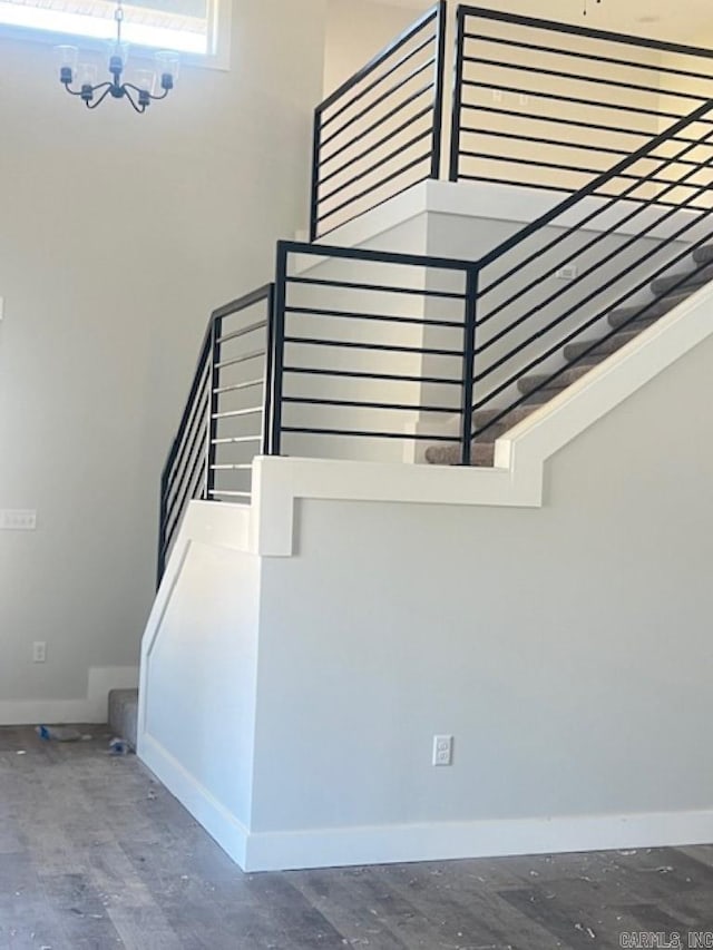 staircase with a chandelier and wood-type flooring