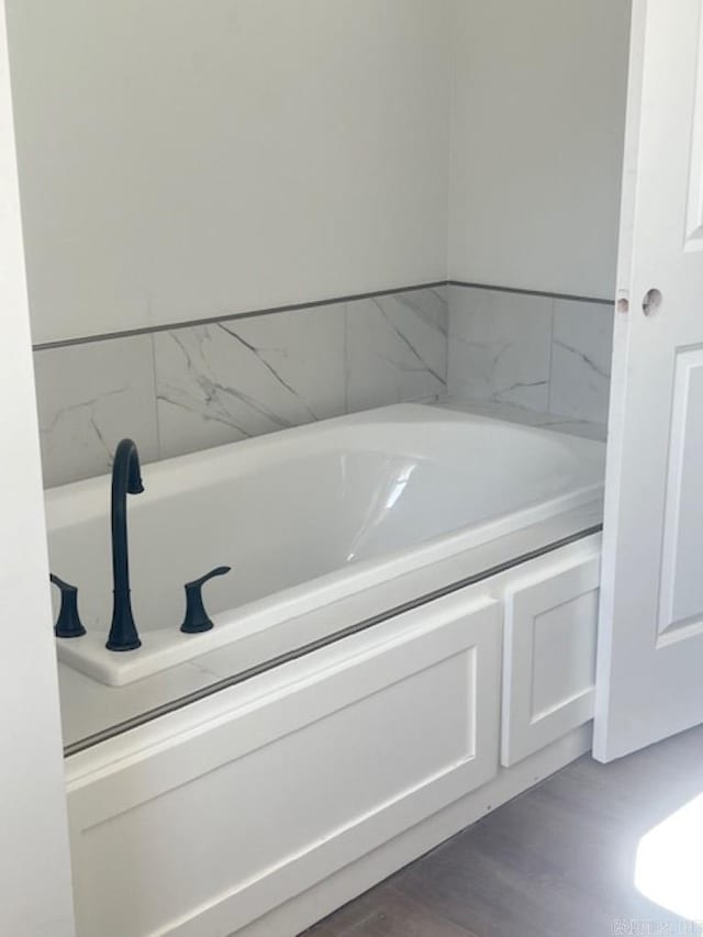 bathroom featuring a washtub and hardwood / wood-style floors