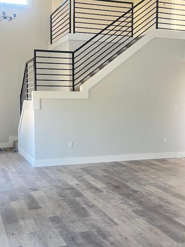 staircase featuring wood-type flooring and a high ceiling