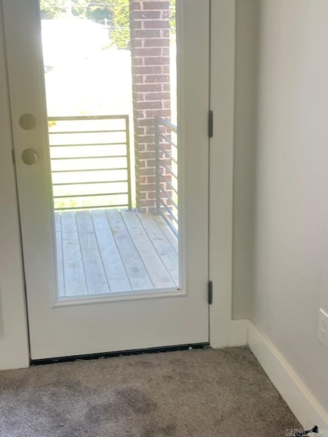 doorway to outside featuring light carpet and a healthy amount of sunlight