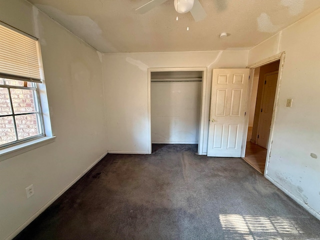 unfurnished bedroom with a closet, ceiling fan, and dark carpet