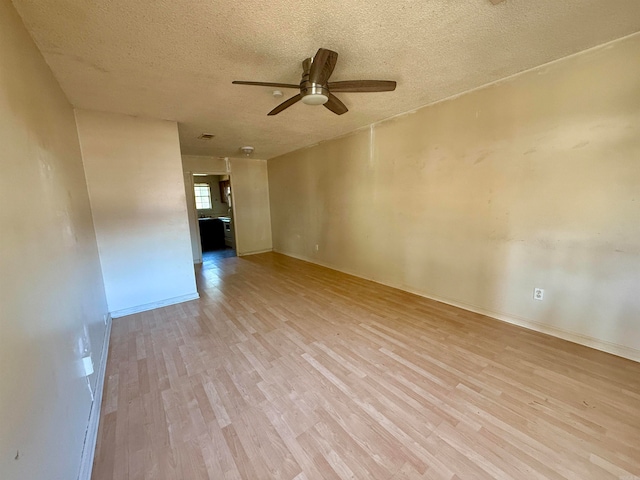 unfurnished room with light hardwood / wood-style flooring, a textured ceiling, and ceiling fan