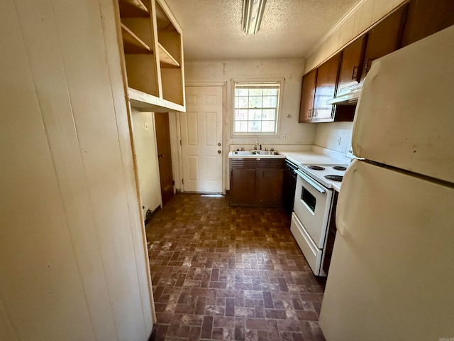 kitchen featuring a textured ceiling, sink, and white appliances