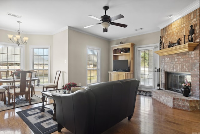 living area with healthy amount of natural light, wood finished floors, and crown molding