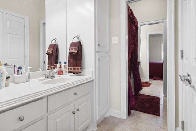 bathroom featuring vanity, tile patterned flooring, and baseboards