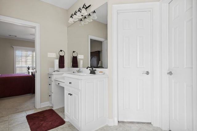 ensuite bathroom with vanity, tile patterned floors, and baseboards