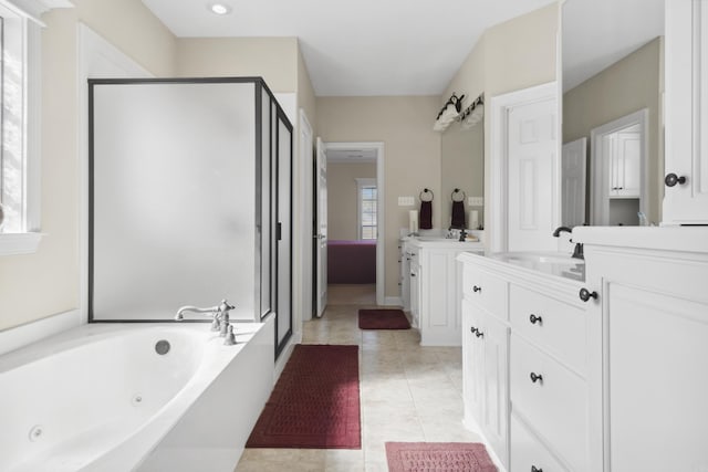 full bath featuring a stall shower, two vanities, a jetted tub, and tile patterned flooring