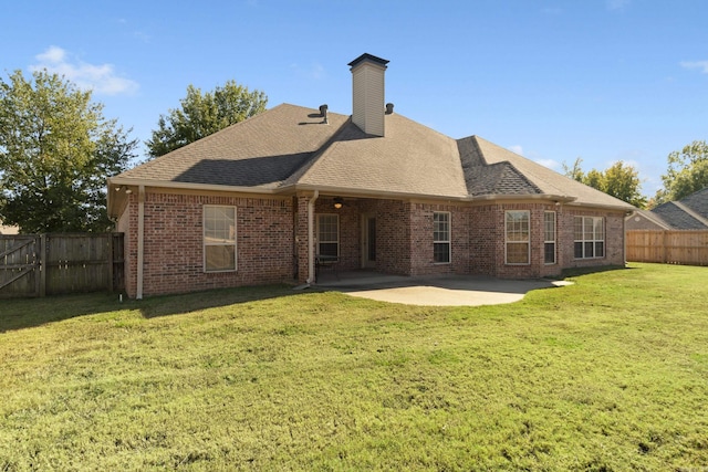 back of house featuring a patio, brick siding, a shingled roof, and a chimney