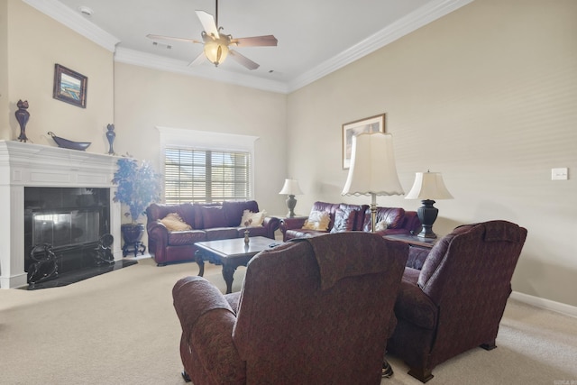 living area featuring carpet flooring, crown molding, a glass covered fireplace, a ceiling fan, and baseboards