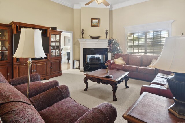living room with carpet, ornamental molding, ceiling fan, and a fireplace with flush hearth