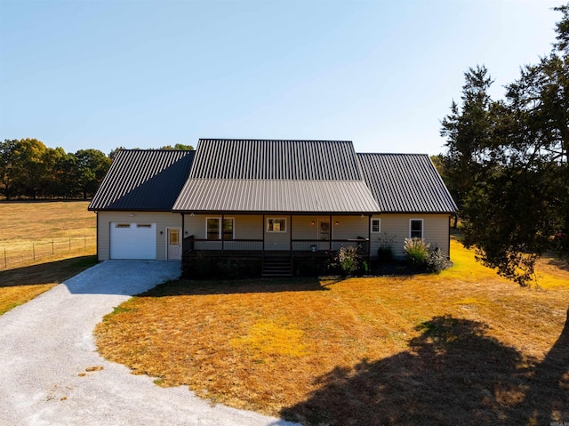 view of front of property featuring covered porch, a front lawn, and a garage