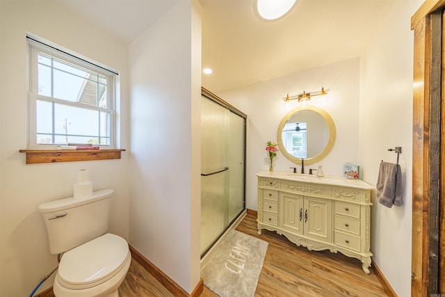 bathroom featuring vanity, toilet, hardwood / wood-style flooring, and a wealth of natural light