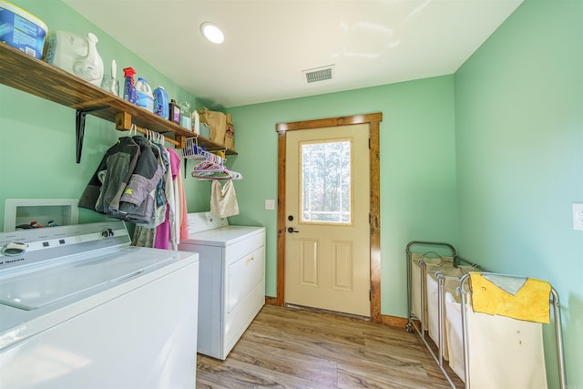 laundry area featuring separate washer and dryer and light hardwood / wood-style floors