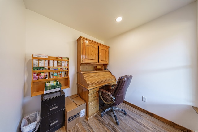 office featuring lofted ceiling and light hardwood / wood-style flooring