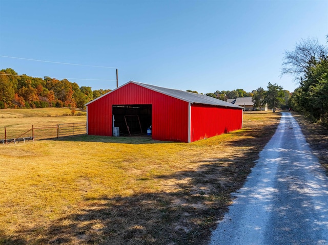 view of outdoor structure featuring a lawn and a rural view