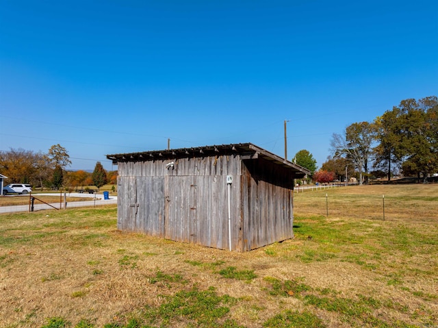 view of outdoor structure with a rural view and a yard