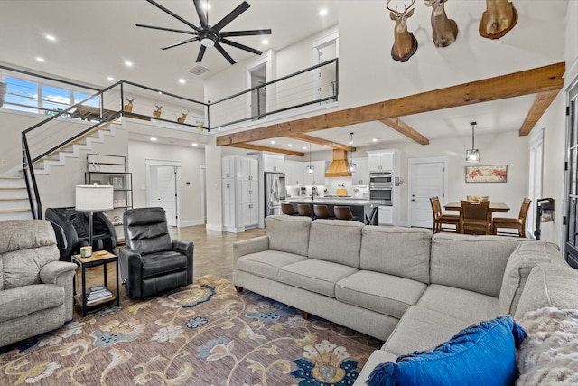 living room featuring beam ceiling, a towering ceiling, and ceiling fan