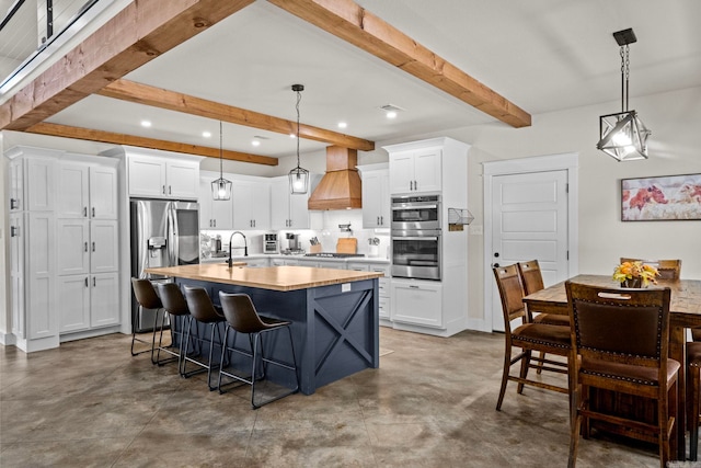 kitchen with pendant lighting, stainless steel appliances, white cabinetry, and custom exhaust hood