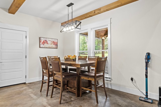 dining area featuring beamed ceiling and concrete flooring