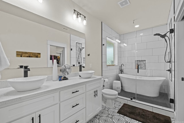 full bathroom with toilet, tile patterned flooring, vanity, tile walls, and shower with separate bathtub