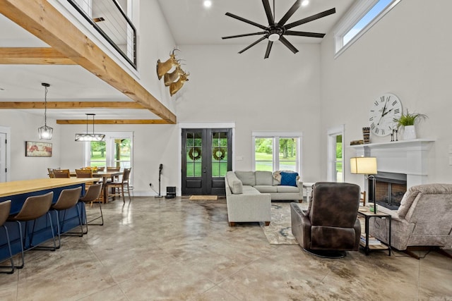 living room with beam ceiling, french doors, a towering ceiling, and ceiling fan