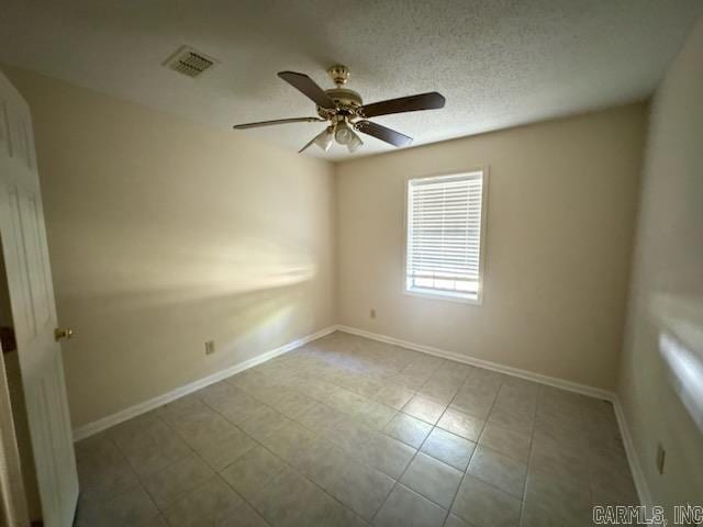 unfurnished room with ceiling fan, a textured ceiling, and light tile patterned flooring