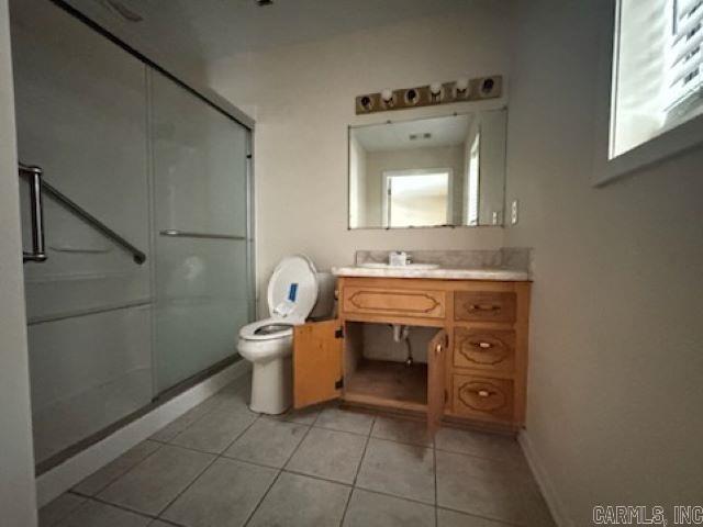 bathroom featuring a shower with door, toilet, tile patterned flooring, and vanity