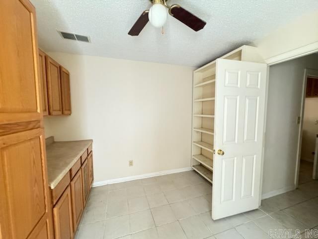 interior space with a textured ceiling and ceiling fan