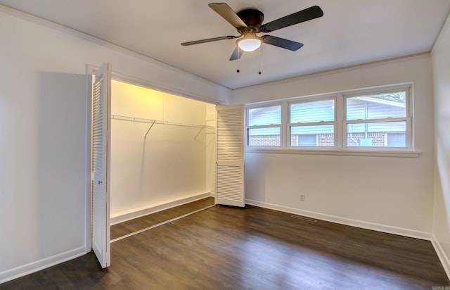 unfurnished bedroom with crown molding, ceiling fan, a closet, and dark hardwood / wood-style flooring