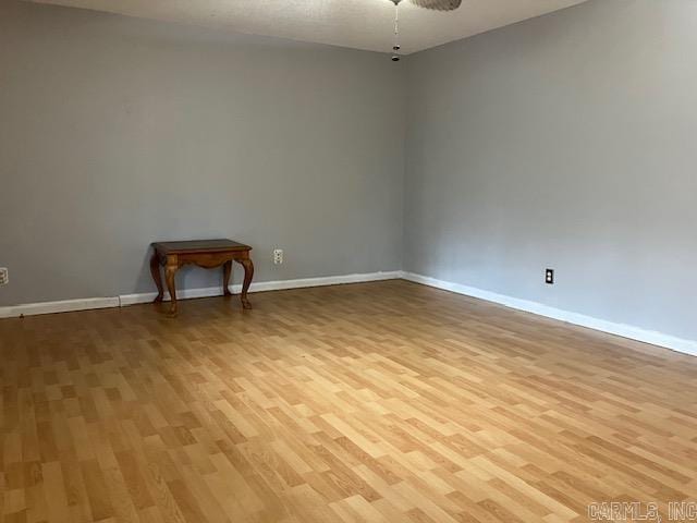 empty room with light wood-type flooring and ceiling fan