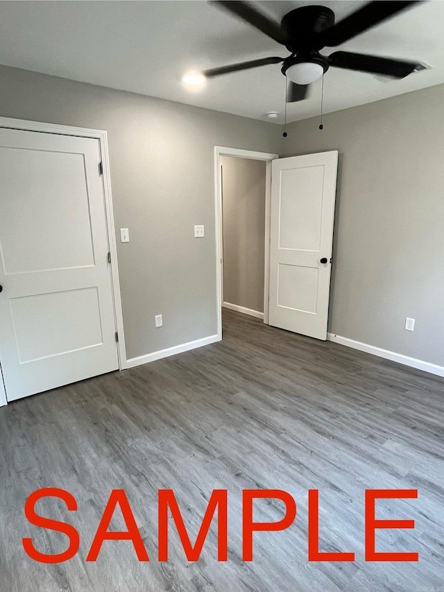 unfurnished room featuring dark wood-type flooring and ceiling fan