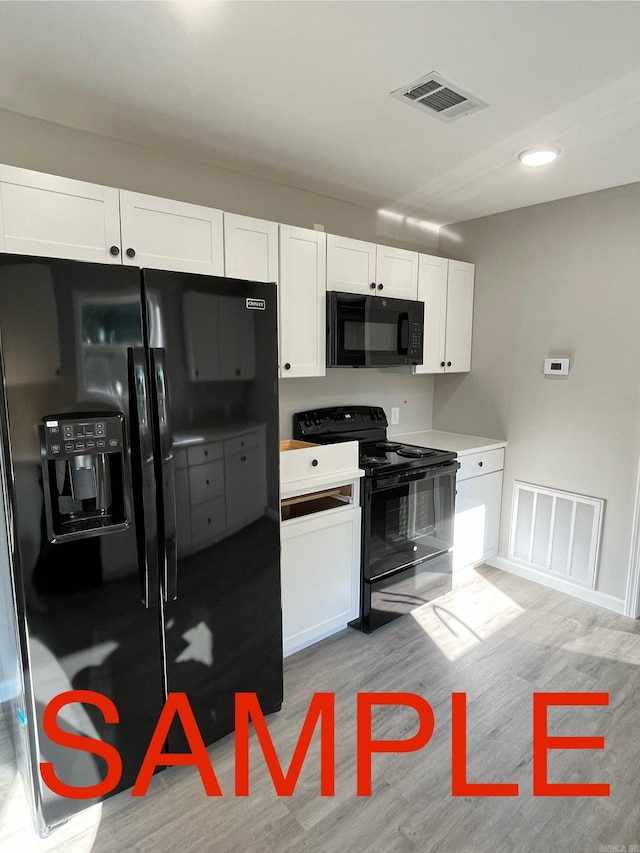 kitchen featuring white cabinetry, light hardwood / wood-style floors, and black appliances