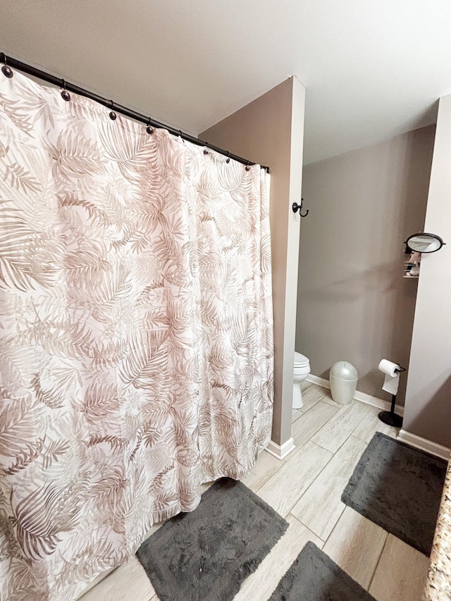 bathroom with curtained shower and toilet