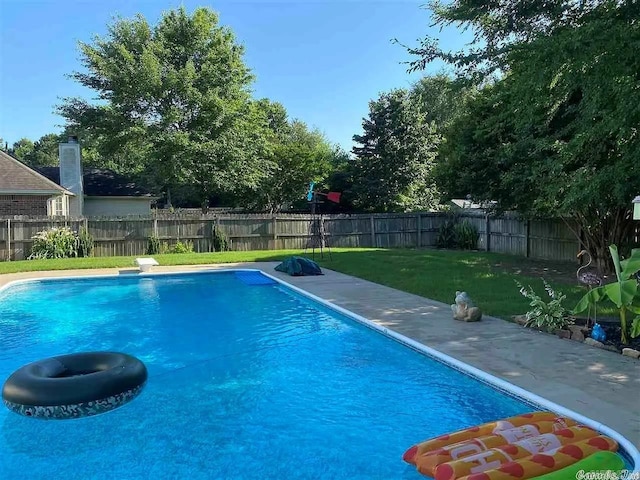 view of swimming pool featuring a yard