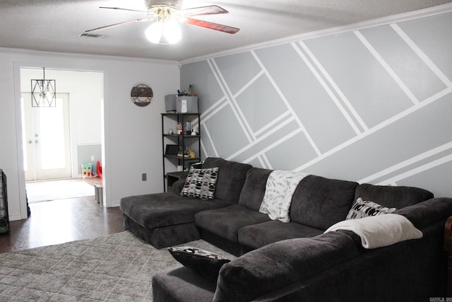 living room featuring ceiling fan, ornamental molding, and a textured ceiling