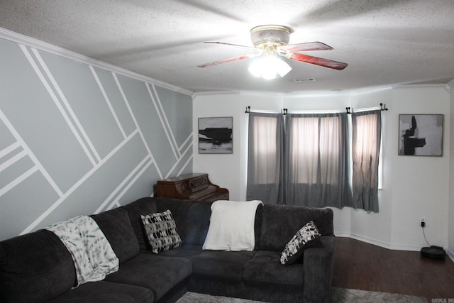 living room with ceiling fan, wood-type flooring, a textured ceiling, and ornamental molding