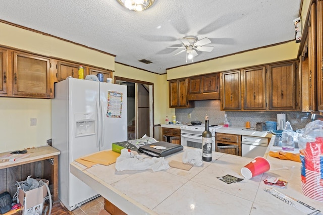 kitchen with kitchen peninsula, ceiling fan, a textured ceiling, crown molding, and white appliances